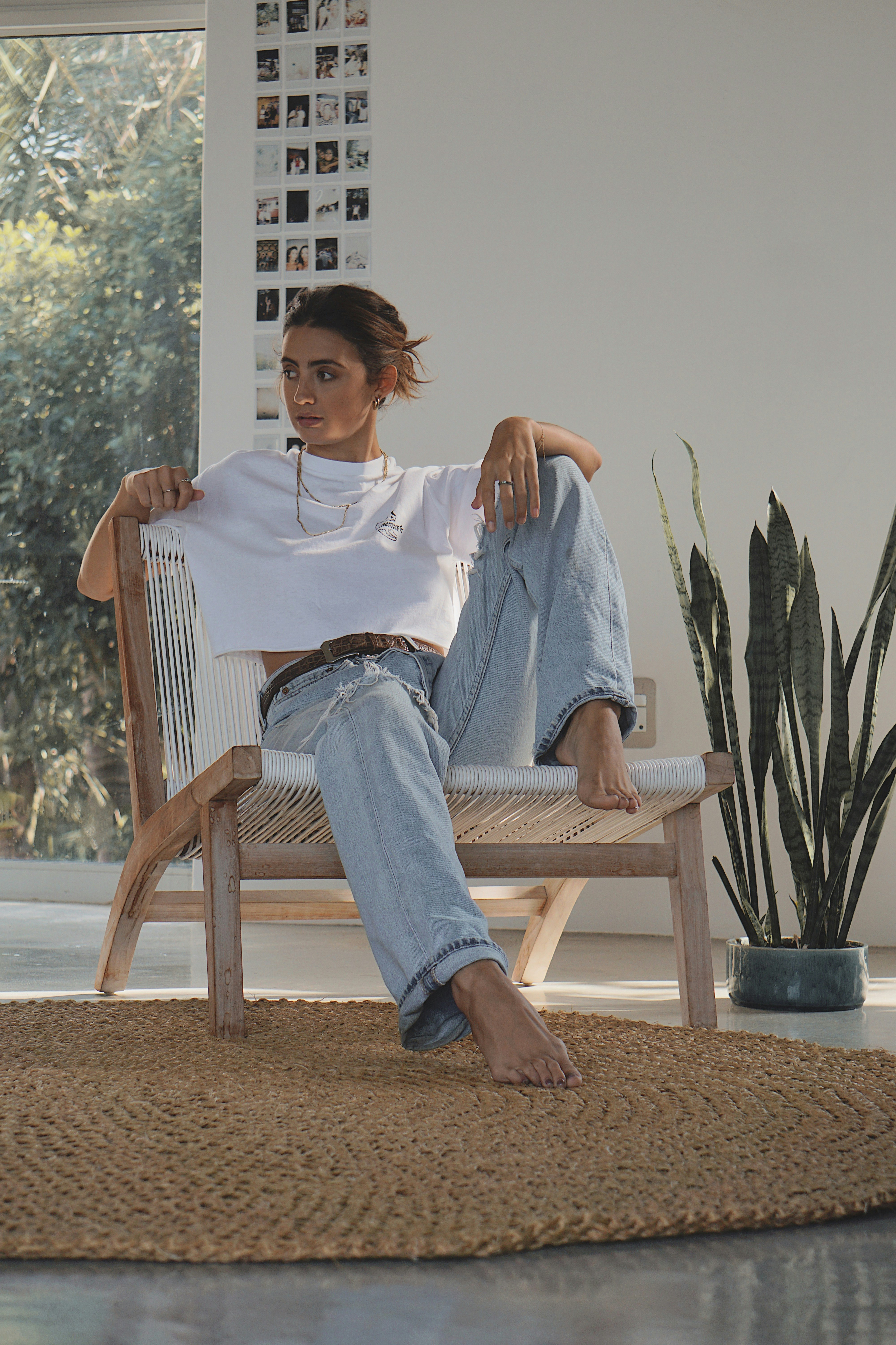 woman in blue denim jacket sitting on brown wooden armchair